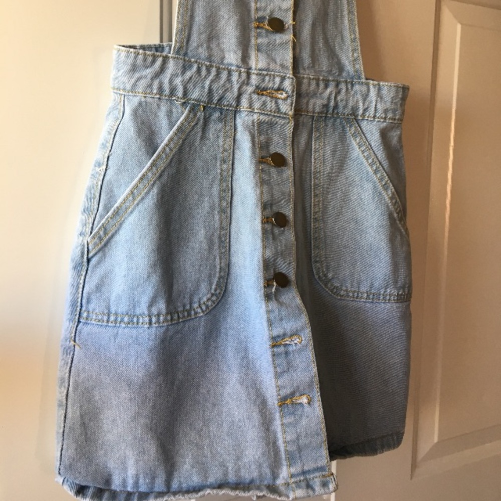 An adorable light wash overall dress